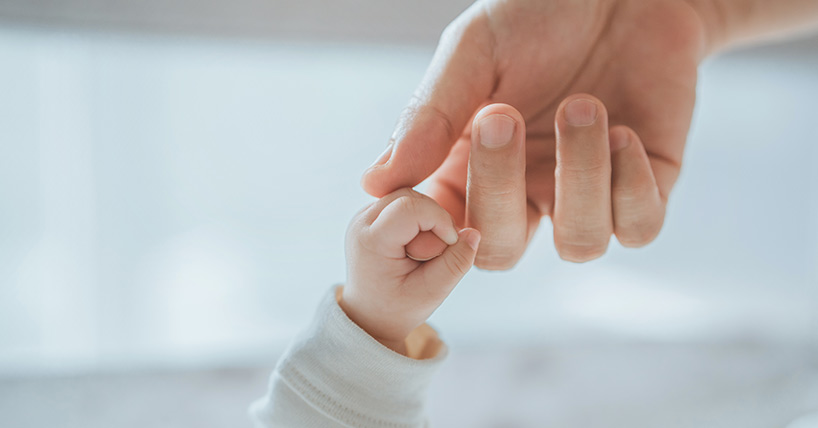 Close-up little hand of child baby holding hand of mother,