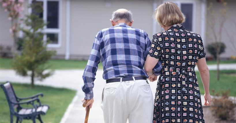 Woman helping senior man walk