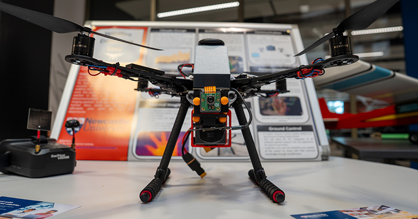 Drone resting on table while being preppred by Aerospace Engineering students