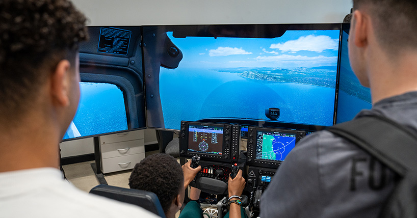 Students learning to fly a simulator plane