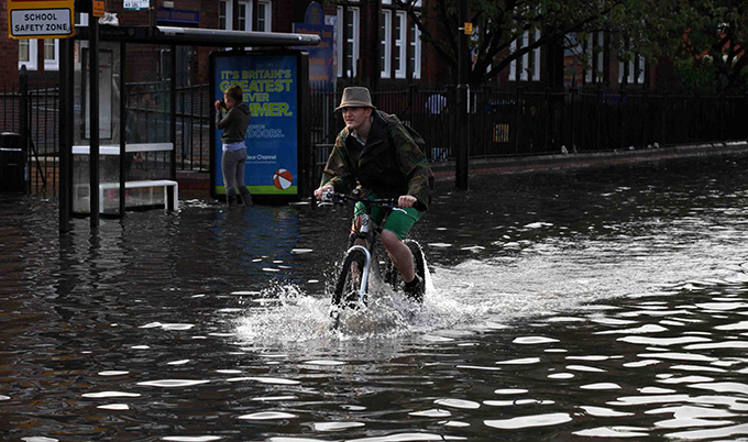 man on a bike cycling through a flood man on a bike cycling through a flood